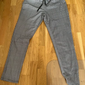 Rutig kostymbyxa med snörning, M - Set med byxor och kavaj i mjukt material( reklam från tex Facebook ) passar så bra med vit t-Shirt under . Snygga kostymbyxor i svartvitt rutigt mönster med diskreta röda och blå linjer. Byxorna har elastisk midja med svart snörning och rak passform. Perfekt för dig som gillar stilrena och trendiga detaljer. Materialet känns mjukt och lätt.priset gäller hela settet