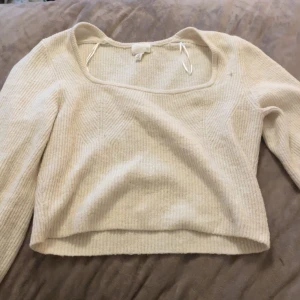 Beige ribbad croppad topp H&M - Säljer en beige croppad topp från H&M med ribbad struktur och fyrkantig halsringning. Toppen har långa ärmar och är gjord i mjukt stickat material som är perfekt för lager-på-lager. Enkel och clean look som funkar till jeans eller kjol. Pris kan diskuteras och köparen står för frakt