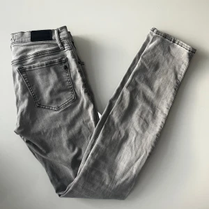 Replay jeans Vivy - Snygga grå jeans från Replay med klassisk femficksdesign och svarta läderpatch bak i midjan. Modellen har smal passform och raka ben, perfekt för dig som gillar stilrena och moderna jeans. Materialet är mjukt och följsamt jeans. W27 L32