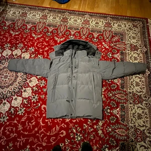 Grå dunjacka från Canada Goose - Säljer en grå dunjacka från Canada Goose. Helt oanvänd men har tappat bort kvittot.