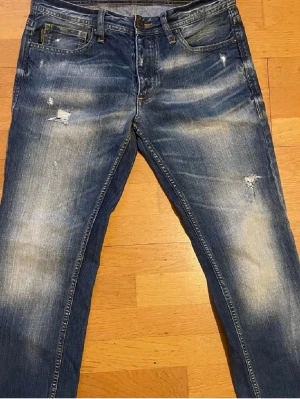 Jeans - Säljer ett bar snygga jeans från Jack and Jones. Perfekta till dig som vill ha ett par stilrena jeans med slitningar. Perfekt till vardagen. Storlek 30 32