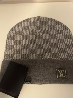 Grå rutig mössa - Säljer en helt ny grå rutig mössa inte använd en enda gång.Får även med prislappen på mössan