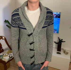 Grå stickad cardigan från Tokyo Laundry  - Skön stickad cardigan i storlek S. Modellen är 187cm. Hör av dig vid funderingar