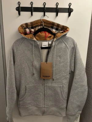 Burberry hoodie zip up - Ny burberry zip up. Den är ganska liten i storlek även fast den är M. Så passar den nog S