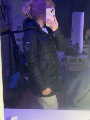 Svart pufferjacka från R-Collection - Säljer en sån fin och varm jacka!! Den har använts men är fortfarande i Okej skick! Den har något typ som färg eller liknande på armen men tror att det går att få bort sen har det lossnat lite av det svarta precis under fickan men det är absolut inget som syns när man har den på sig! Luva utan päls! Och silver-detaljer🤍 köptes för 3500! Den har även ett litet hål inuti fickan men det går att sy!! Hör av er vid intresse! Pris kan diskuteras och kan tänka mig att sänka pris✨