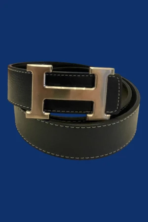 H bälte - Mörkblått H bälte i äkta skinn med ikoniskt silverfärgat H-spänne. Bältet har vit kontrastsöm längs kanterna och klassisk, stilren design som passar till allt. Perfekt accessoar för dig som vill ha en lyxig och tidlös detalj.