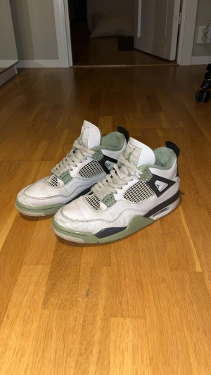 Jordan 4 Seafoam - Nike Air Jordan 4 Retro sneakers i vitt och grönt med svarta detaljer. De är användna och finns en del skavanker som syns på bilderna. Köpta för 2800. Hör gärna av dig vid fråga eller fundering!