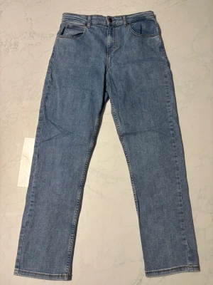 Blå raka jeans från Lee, 15-16Y - Snygga ljusblå jeans från Lee med klassisk femficksdesign och raka ben. Jeansen har Lee-logga på bakfickan och läderpatch i midjan. Passar dig som gillar en enkel och tidlös look. Tillverkade i slitstarkt denim med kontrastsömmar.