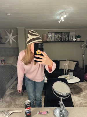 Stickad zebramönstrad mössa i beige och brun - Säljer en riktigt snygg stickad mössa med zebramönster i beige och brun. Mössan har en klassisk form med uppvikt kant och är perfekt för att ge din outfit lite edge. Materialet är mjukt och värmande, passar grymt till höst och vinter.