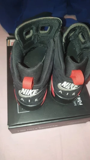 Nike Air Jordan 6 Retro svart/röd - Nike Air Jordan 6 Retro sneakers i svart med röda detaljer och Jumpman-logga på sulan. Skorna har snörning, högt skaft och platt sula. Materialet är en mix av syntet och mocka, med klassisk Air-dämpning. Perfekt för dig som gillar ikoniska basketskor med cool design.