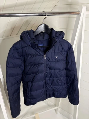Gant dunjacka 13-14 years - Tja, säljer nu denna otroligt snygga vinterjackan för pang pris. 13-14 years och 158/164cm. Skickar inom 24h. Skriv vid funderingar och frågor! Endast ett litet hål vid ryggen. 