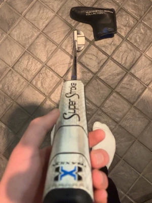Superfin Cleveland Putter - Säljer nu min Face Balanced Cleveland Huntington Beach Collection 6 center shafted putter!  34 Tum  Köpt 2025 och har inte alls använt puttern mycket men när den användes har jag puttat hur bra som helst.   Den har en precisionsfräst träffyta med ett grovt, diamantformat mönster som är utformat för att öka friktionen och ge en sannare, mer konsekvent rull på bollen.  Puttern har ett SuperStroke Tour grepp och headcover medföljer självklart!   Hör gärna av dig vid minsta fundering eller intresse!