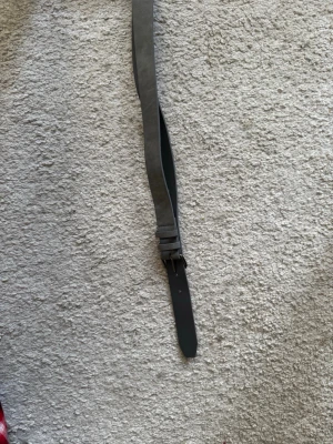 Mörkgrått skärp i mocka - Snyggt och stilrent mörkgrått skärp i mocka med enkel design. Perfekt för att lyfta vilken outfit som helst. Skärpet har ett klassiskt spänne och passar till både jeans och byxor.