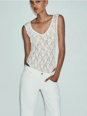 Vit spetsbody Zara  - Säljer en vit body i spets med v-ringning och ärmlös design. Toppen har ett blommigt spetsmönster och är figurnära, perfekt att styla med jeans eller kjol. Materialet är genomskinligt och stretchigt för en snygg passform. Den är ifrån Zara i storlek S. Den är aldrig använd med prislappen kvar❤️