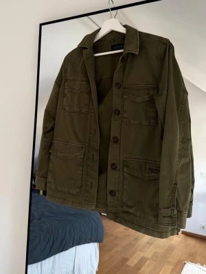 Grön overshirt från Lexington XS - Grön jacka/overshurt från Lexington med fyra stora fickor framtill och klassisk krage. Jackan har knäppning med knappar. Perfekt för lager-på-lager, skön, knappt använd. Nypris 2500kr.🔥