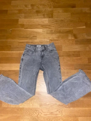 Ljus gråa bootcut jeans - Säljer ett par grå jeans med klassisk bootcut passform. Jeansen har fem fickor, normal midja och är tillverkade i mjukt bomullsjeansmaterial. Perfekta för dig som gillar en avslappnad men ändå stilren look.