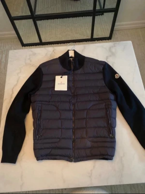 Mörkblå teddyjacka från Moncler - Riktigt skön Moncler cardigan till ett bra pris. Perfekt till vädret. Skick är 10/10 använt ca 10 gånger. Lappar osv hänger med (Digitalt kvitto finns) kom privat för fler bilder. Storlek L passar M är ungefär 175 och den passar mig perfekt.