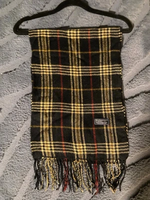 Klassisk Burberry Halsduk - Burberry halsduk 🤎  Klassisk Burberry-halsduk i det välkända rutmönstret. En tidlös favorit som aldrig går ur stil.  ✨ Detaljer: – Material: Lammull – Färg: Svart/Brun/Vit/Röd – Mått: 170 cm x 30 cm – Skick: Mycketbra – Original: ja  Perfekt till höst & vinter och funkar både casual och uppklätt. Skickas snabbt 📦  Pris kan diskuteras.