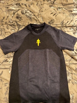 Youngla Golds Gym Compression T-Shirt - Fullständigt namn på produkt är GOLD'S IRON LEGACY COMPRESSION TEES. Färgen är navy, dvs en mörkblå och loggan därframme samt bak är gul med gummi, dvs kvalitativt. Sitter tight, så Large passar bra för mig som är oftast storlek medium på plagg. Plagget är testat en gång enbart, det är i väldigt fint skick. Slutsålt på hemsidan.