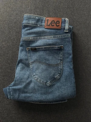 Blå Straight fit jeans från Lee - Straight fit jeans från Lee, storlek W32 L32. Snygg tvätt och inga defekter. Hör av er vid funderingar.