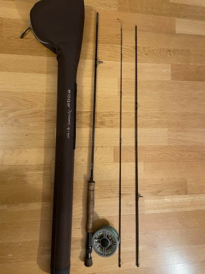 Flugfiskespö Edge Dynamic 9' #4 - Säljer ett brunt flugfiskespö från Edge, modell Dynamic 9' #4. Spöet är fyrdelat och har korkhandtag samt medföljer en matchande rulle och ett brunt fodral med dragkedja. Perfekt för dig som gillar fiske och vill ha ett smidigt spö att ta med ut.