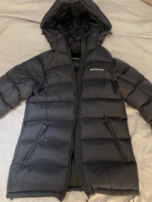 Svart dunjacka från Peak Performance - Svart dunjacka från Peak Performance. Säljes pga den inte kommer till användning, väldigt bra skick då den är använd 2 ggr. Storlek XS Nypris 4200kr 
