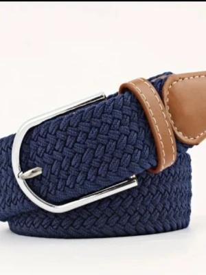 Flätat bälte med skinn-detaljer - Snyggt flätat bälte i marinblått och svart med bruna skinn-detaljer och silverspänne. Perfekt accessoar för att lyfta din outfit med en stilren touch. Bältet har klassisk design och passar till många olika looks.