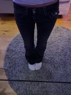 Mörkgråabootcut jeans - Säljer ett par mörkgråa bootcut jeans med klassiska fickor både fram och bak. 