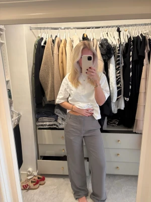 Gråa vida kostymbyxor med låg midja - Säljer ett par gråa/grön kostymbyxor med medelhög midja och vida ben. 