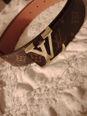 Brun guld L bälte  - Säljer en brun guldig L bälte som är 105cm lång och är oanvänd, 150 är absolut sista priset 