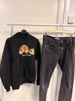 Palm Angels outfit  - en svart hoodie med björnmotiv från Palm Angels, svarta jeans och svarta sneakers.