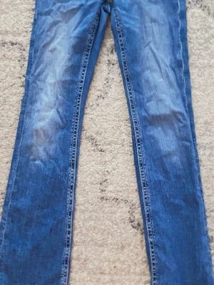 Blå raka jeansbyxor ifrån Gina tricot  - Snygga blå jeansbyxor med klassisk rak passform och lätt slitning framtill. Byxorna har fem fickor och normal midja. Perfekta för dig som gillar en enkel och tidlös jeansstil. De har världens snyggaste bakfickor. Säljer pga att de är för korta 