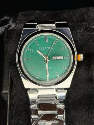 Irlandy Dublin Day-Date - Stainless Steel *Helt ny* - Irlandy Dublin Day-Date i rostfritt stål, helt ny och oanvänd. Stilren och klassisk herrklocka med grön urtavla och day-date-funktion som ger ett tidlöst men modernt intryck. Passar perfekt till vardagsbruk men funkar även bra till mer uppklädda tillfällen.