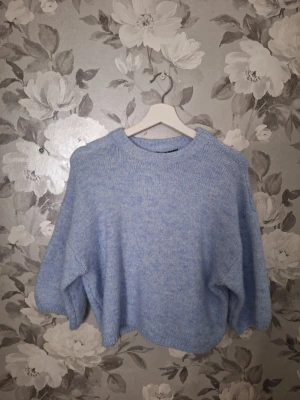 Ljusblå stickad tröja Gina Tricot - Supermysig ljusblå stickad tröja från Gina Tricot i oversized modell. Tröjan har rund halsringning och långa ärmar, perfekt för lager på lager under kyliga dagar. Passar dig som gillar en relaxed och chill vibe.