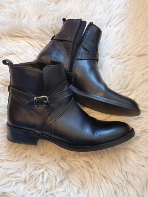 Svarta boots, Rizzo, storlek 38 - Snygga svarta boots i skinn med rund tå och låg klack från Rizzo. Storlek 38. Använda men i väldigt bra skick. 