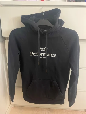 Svart Peak Preformance hoodie🫶🏻 - Säljer nu min svarta Peak Preformance hoodie som e använd mycke men i jättefint skick. De ända som syns att den är använd är hoodie snörena längst nere där den blivit lite cooparfärgade istället för silver🫶🏻💕