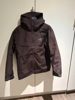 Mörkbrun Arc'teryx 3:1 Gore-tex jacka  - 3:1 jacka  med gore-tex i brun skaljacka och svart dunjacka. Man kan ta isär jackan med dragkedja ( skicka om ni vill ha bild på de!)så att de blir en  skaljacka och en dunjacka, blir ju en jacka med bårda också! Stl är XXL men skulle säga att den är med som en XL/L.