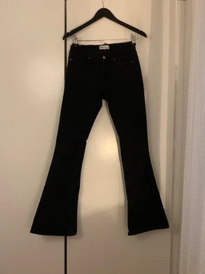 Svarta bootcut jeans från Zara - Säljer ett par svarta bootcut jeans från Zara med medelhög midja. Jeansen har en snygg utsvängd passform 