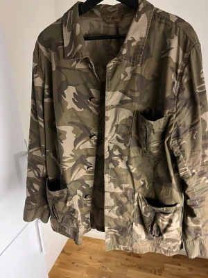 Camouflage overshirt från Stenströms - Snygg overshirt från Stenströms i klassiskt camouflage-mönster. Jackan har flera stora fickor framtill, knappar och krage. Tillverkad i bomull, perfekt för lager-på-lager och chill stil. Passar dig som gillar street och utility vibes.