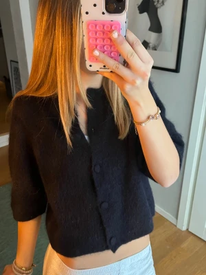 Marinblå kofta från & Other Stories - Köpt för 700kr💖Mysig svart kofta från & Other Stories med stora klädda knappar framtill. Koftan är croppad och har halvlånga ärmar. Tillverkad i ett fluffigt, stickat material som känns lyxigt och passar perfekt till lager på lager under höst och vinter.