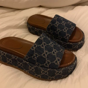 Gucci sandaler  - Säljer ett par snygga blå sandaler från Gucci i jeansmaterial. De har en bekväm platåsula och är perfekta för sommaren. Skorna är i mycket bra skick, har låda samt bagsen till skorna. De är i storlek 36 men skulle säga att de passar 37