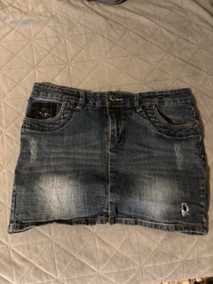 Kort vintage style jeanskjol - Säljer en kort vintage style jeanskjol i bra skick. Mått finns med i bilderna! Skulle säga att den är som en medium i storlek.