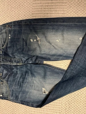 Dondup music slim fit jeans i mycket bra skick! - Säljer dessa otroligt snygga dondup jeans i modellen music, som är slim. Sjukt snygg wash plus riktigt snygga slitningar, passar på nästan vem som helst och till nästan alla tröjor! Ett par ”lite shysstare” dondisar. Pris kan diskuteras vid snabb affär, kan ta fler bilder om det behövs. Eftertraktad modell som är slutsåld nästan överallt!