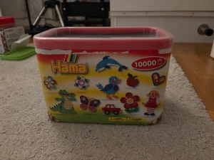 Förpackning med glittriga Hama-pärlor - En förpackning med glittriga Hama-pärlor i färgerna röd, gul, grön, blå, vit och lila.