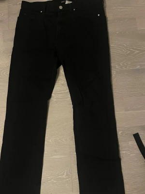 Mörkblå chinos J.Lindeberg - Säljer ett par svarta jeans från J.Lindeberg med klassisk femficksdesign och diskret JL-logga i metall på myntfickan. Rak passform. W32/L32