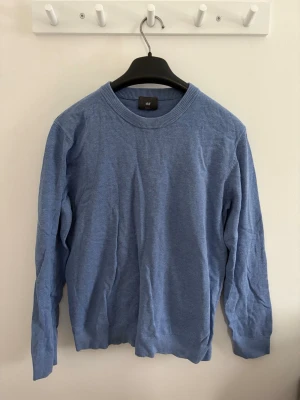 Herr Blå långärmad tröja  - En stilren blå tröja från H&M i slim fit-modell i storlek XS/S. Tröjan har rund halsringning, långa ärmar och ribbade muddar vid ärmslut och nederkant. Perfekt för dig som gillar en enkel och clean look.