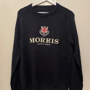 Morris stickad tröja - Snygg svart stickad tröja från Morris i storlek medium. Tröjan har broderad logga. Rund hals och ribbade muddar.
