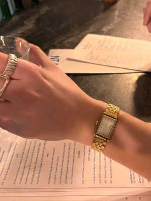 Mockberg klocka - Klocka från Mockberg i guld. Den är i nytt skick har endast använt en gång. Utverket fungerar som det ska. Har tagit bort två länkar så att klockan passar mindre handleder men skickar även med de två länkarna jag tagit bort. Nypris:1899 kr. 