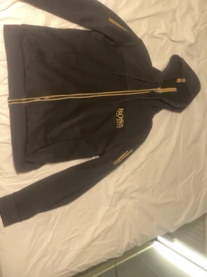 Hugo Boss Zip Tröja - Riktig snygg svart Hugo Boss tröja med jätte snygga guldiga detaljer.