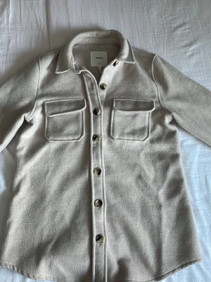 Beige kappa!! - Snygg beige kappa. Perfekt till vardagen. Använd fåtal gånger och säljer pågrund av att den inte kommer till användning. Postar inom 24 timmar!!💕